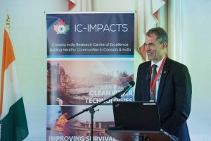 Bill Barrable, CEO of the Rick Hansen Institute, at the podium in front of an audience at IC-IMPACTS Gateway to India, Innovation, and Economic Development