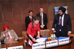 Photo of Honourable Kirsty Duncan signing agreement with other dignitaries in New Delhi, India, February 2018